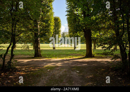 Champs-sur-Marne, Frankreich - Oktober 6, 2019: Geradlinige garten Gasse mit Linden bilden gerade Kanten und eine Apollo Statue in der Mitte, nehmen Stockfoto