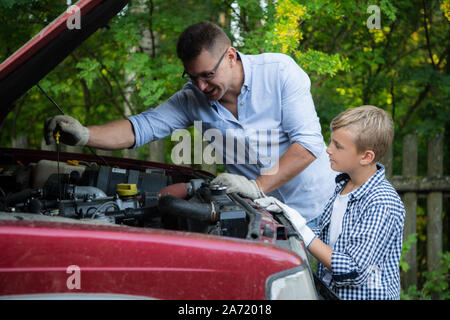 Vater und Sohn sind die Reparatur des Autos im Freien. Auto Reparatur Konzept. Stockfoto