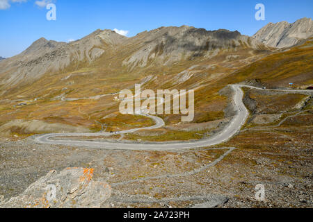 Einen malerischen Blick auf die Berge mit dem kurvenreichen Straße, die zu den Colle dell'Agnello Alpenpass an einem sonnigen Spätsommertag, Chianale, Cuneo, Piemont, Italien Stockfoto