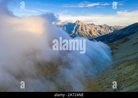 Bewölkter Himmel über Spluga Berg Straße im Herbst von oben, Kanton Graubünden, Schweiz Stockfoto