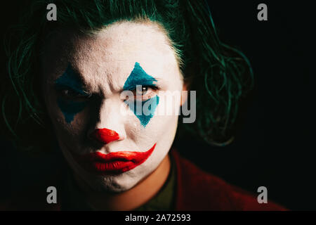 Make-up-Joker mit grünen Haaren für Halloween. Close-up Gesicht auf schwarzen Hintergrund. Stockfoto