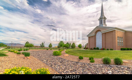 Panorama Rahmen sonnigen Tag mit bewölktem Himmel über Kirche mit Turm und großen Bogenfenster Stockfoto