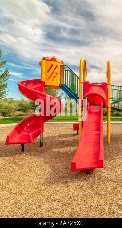Vertikale Ausrichtung auf leeren Spielplatz der Kinder an einem Park mit roten Folien und Klettern bars Stockfoto