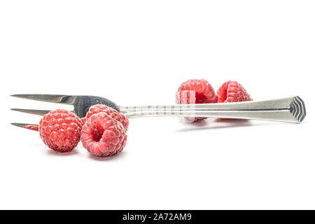 Menge ganze Frische crimson Himbeere mit Stahl Stahl Gabel und Löffel auf weißem Hintergrund Stockfoto