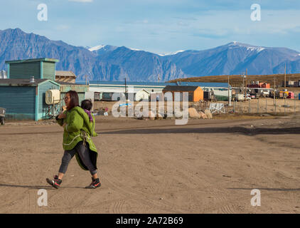 Eskimo - Inuit Frau, die ihr Baby auf dem Rücken in Pond Inlet, Baffin Island, Kanada. Stockfoto