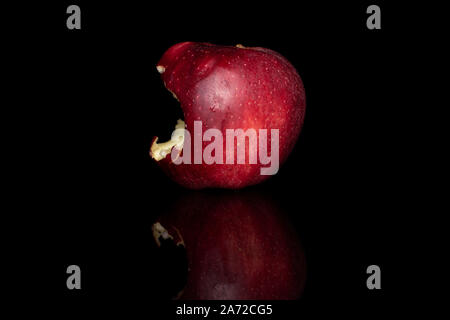 Ein ganzes Gebissen frischen Apfel Red Delicious auf schwarzem Glas isoliert Stockfoto