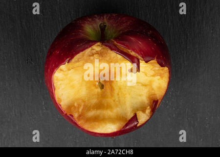 Ein ganzes Gebissen frischen Apfel Red Delicious flatlay am grauen Stein Stockfoto