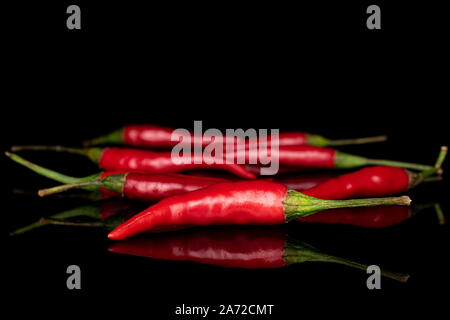 Menge ganze Hot red chili auf schwarzem Glas isoliert Stockfoto