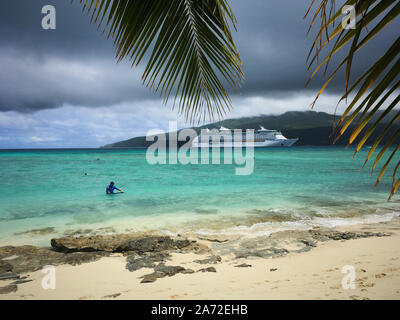 Eine große Carnival Cruise Schiff vor Anker in einer Bucht von Vanuatu Insel, die nur aus einem idillic Strand, wo Touristen schwimmen. Stockfoto