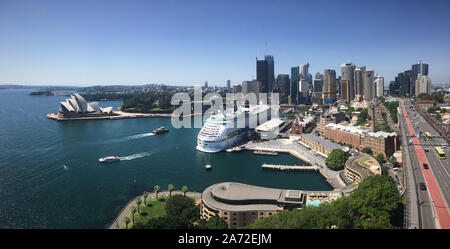 Die beeindruckende Skyline von Sydney mit dem Opernhaus von Sydney und ein Karneval Kreuzfahrtschiff von Sydney Harbour Bridge. Stockfoto