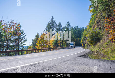 Big Rig Classic blau pro Amerikanische Motorhaube Semi Truck mit vertikalen Auspuffrohre Transport gefroren Cargo in gekühlten Auflieger, die auf dem Stockfoto