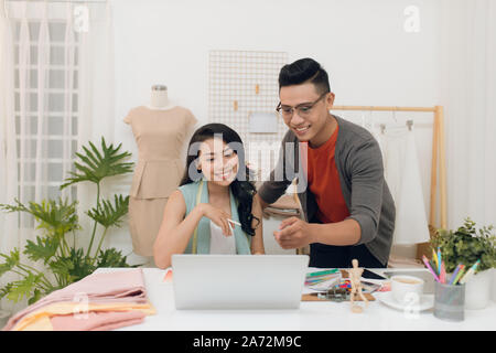 Foto fröhliche Frau und Mann Designer im Studio arbeitet Stockfoto