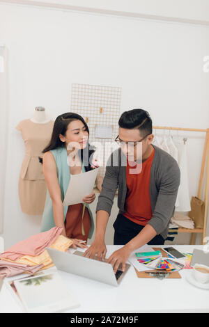 Junge Frau und Mann Mode mit Laptop für neue Ideen zu suchen Designer Stockfoto