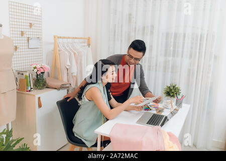 Junge weibliche und männliche Fashion Designer Team sprechen über neue Kollektion, diskutieren Stoffe und Muster für die neue Kollektion in Schneiderin s studio o Stockfoto