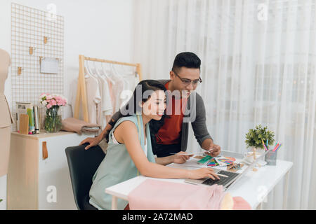 Zwei Mode-Designer arbeiten gemeinsam an einem Tisch Stockfoto