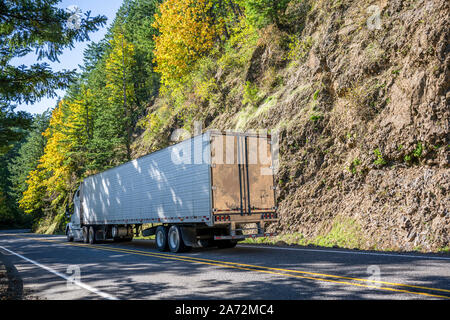 Big Rig Classic blau pro Amerikanische Motorhaube Semi Truck mit vertikalen Auspuffrohre Transport gefroren Cargo in gekühlten Auflieger, die auf dem Stockfoto