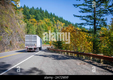 Big Rig Classic blau pro Amerikanische Motorhaube Semi Truck mit vertikalen Auspuffrohre Transport gefroren Cargo in gekühlten Auflieger, die auf dem Stockfoto