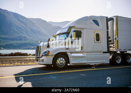 Big Rig classic Weiß pro Amerikanische Motorhaube Semi Truck mit Kühlschrank für den Transport von gefrorenen Fracht in gekühlten Auflieger auf dem moun Stockfoto