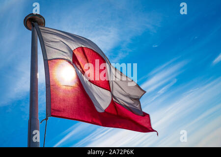 Grönland Flagge - grönländischer Flagge gegen den blauen Himmel. Schuß auf Grönland im Sommer Tag. Die Nationalflagge von Grönland. Stockfoto