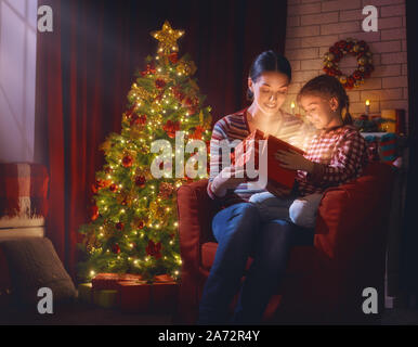 Frohe Weihnachten und schöne Feiertage! Mutter und Kind Mädchen mit Magic Geschenk zu Weihnachten. Weihnachten Familie Traditionen. Stockfoto