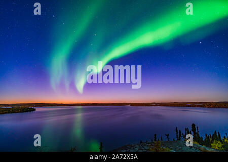 Einen Bogen von Northern Lights erscheint in der Abenddämmerung über Prelude Lake in der Nähe von Yellowknife, NWT, am 9. September 2019. Der Große Wagen ist auf der linken Seite. Ca Stockfoto