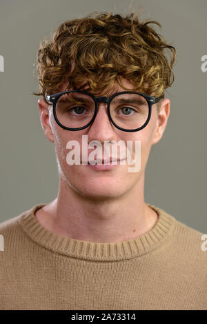 Gesicht der jungen gutaussehenden Mann mit Brille mit Kamera suchen Stockfoto