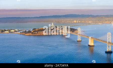 Sonnenuntergang von Yerba Buena Island und die Bay Bridge; die Rauchwolke von kincade Feuer im Hintergrund sichtbar; San Francisco, Kalifornien Stockfoto