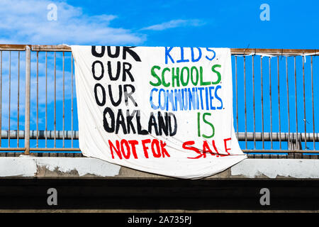 Okt 18, 2019 Oakland/CA/USA - Schild mit der Aufschrift "Unsere Kinder, unsere Schulen und Gemeinschaften Oakland ist nicht Verkauf' auf ein brueckengelaender angezeigt, Referenzieren t Stockfoto