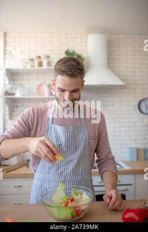 Man Gefühl aufgeregt vor dem Essen Salat beim Kochen Stockfoto