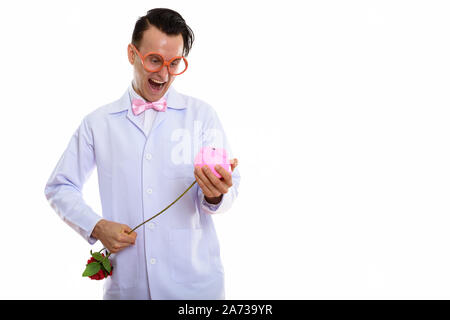 Portrait von verrückten jungen Mann Arzt spielen mit Sparschwein Stockfoto