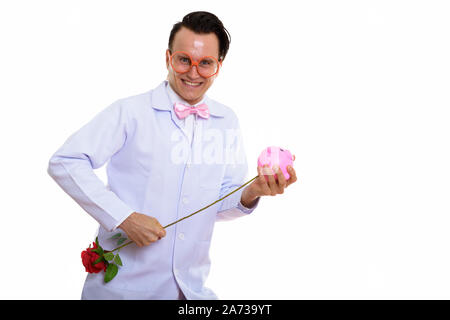 Portrait von verrückten jungen Mann Arzt spielen mit Sparschwein Stockfoto