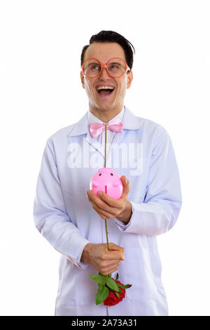 Portrait von verrückten jungen Mann Arzt spielen mit Sparschwein Stockfoto