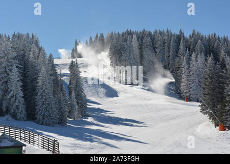 Am Ende des Tages, mehrere Schneekanonen in Aktion, Überlappung der Skipisten mit künstlicher Schnee Stockfoto