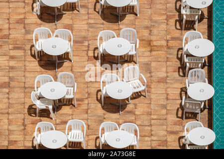 Top Blick auf weiße, runde Tische und Stühle aus Kunststoff Stockfoto