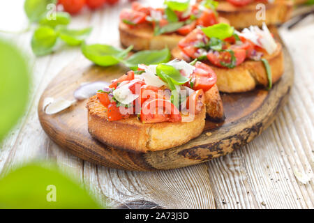 Herzliche Italienische bruschetta: knusprig gebackene italienische Ciabatta Brot mit Tomaten, Basilikum und Parmesan, als Vorspeise serviert. Stockfoto