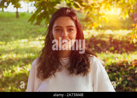 Junge Frau lächelnd in der Natur Stockfoto