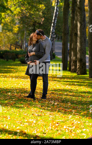 Trendy romantische junge Paar Küssen im Park im Herbst, als sie in eine enge Umarmung stehen Stockfoto