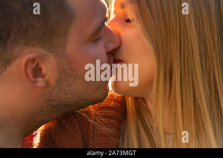 Junges Paar in der Liebe einen romantischen Kuss in der Nähe zu 7/8 Blick auf ihre Gesichter im Profil Stockfoto