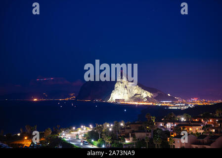 Gibraltar ist Abends beleuchtet aus Alacaidesa, in Spanien. Stockfoto