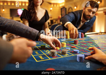 Eine Gruppe von Leuten, die Spieler spielen Glücksspiel Poker Roulette im Casino Stockfoto
