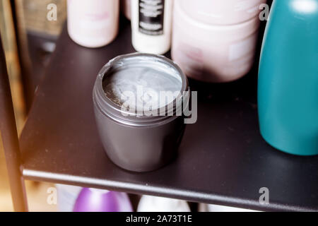 Hausgemachte graue Gesichtsmaske und Peeling auf dem Tisch. Das Konzept der Haarpflege, Schönheit, Kosmetik, Körperpflege, Haar Behandlung. Stockfoto