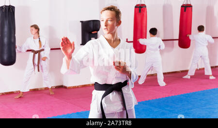 Portrait von Jungen im Kimono Ausübung neue Techniken während taekwondo Klasse im Gym Stockfoto