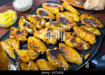 Crispy Fried Chicken Wings auf schwarz Grillpfanne mit cremiger Senfsauce Stockfoto