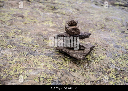 Gestapelte Steine für Trekking Route in der norwegischen Landschaft auf dem Felsen. Stockfoto