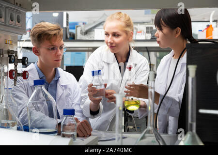 Innenraum der modernen chemischen Labor mit internationalen Gruppe von Wissenschaftlern mit Lab equipment während der Forschung Stockfoto