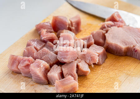 Frischen, rohen Thunfisch Steaks, in Stücke schneiden auf einer hölzernen Schneidebrett Stockfoto