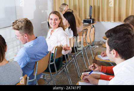 Junge Schülerin lebhaften Gespräch mit Ihr groupmates während des Unterrichts im Hörsaal Stockfoto