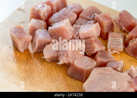 Frischen, rohen Thunfisch Steaks, in Stücke schneiden auf einer hölzernen Schneidebrett Stockfoto