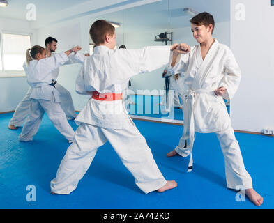 Freundlichen jungen Ausbildung in paar Karate Technik während der Klasse zu verwenden Stockfoto