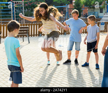 Glückliche Kinder Überspringen auf chinesische Springen elastische Kordel im Hof Stockfoto